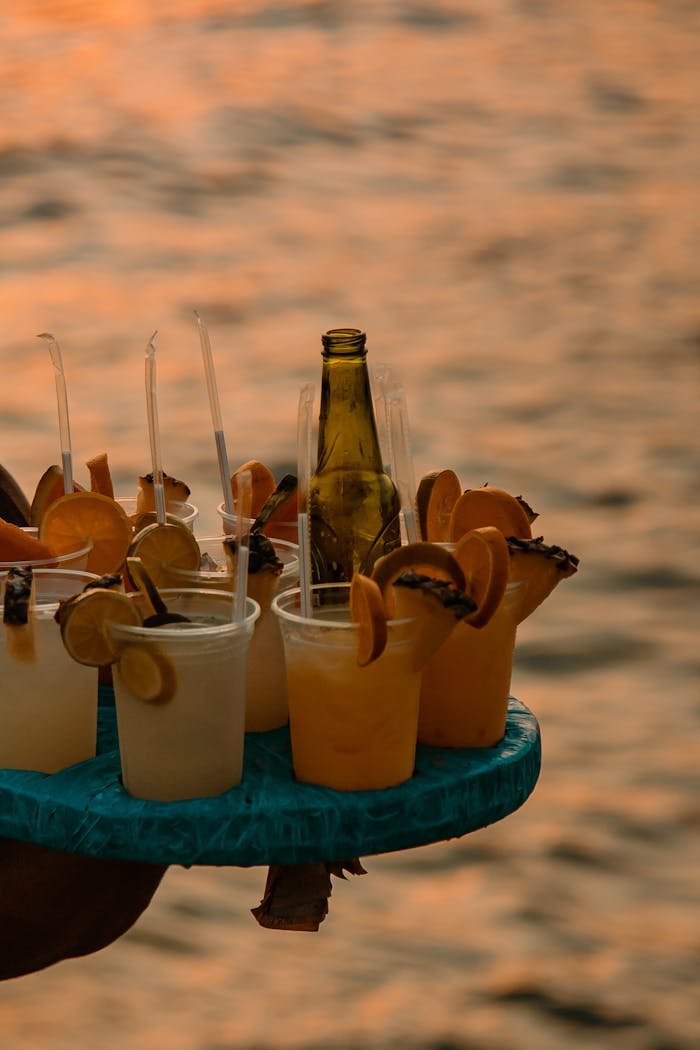 A vibrant selection of citrus cocktails served at sunset by the waterside, offering a refreshing experience.